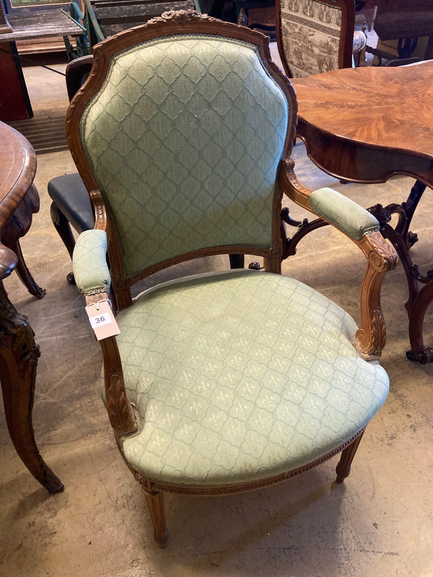 An Edwardian carved and stained beech fauteuil, width 58cm